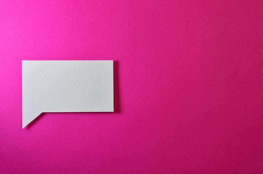 A pink blank wall with an empty, white speech bubble.